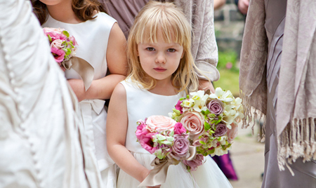 Bride and bridesmaid walking into church holding a beautiful bouquet of flowers